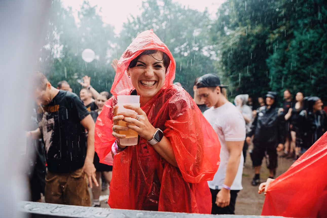 Tanzende Frau in rotem Regenponcho