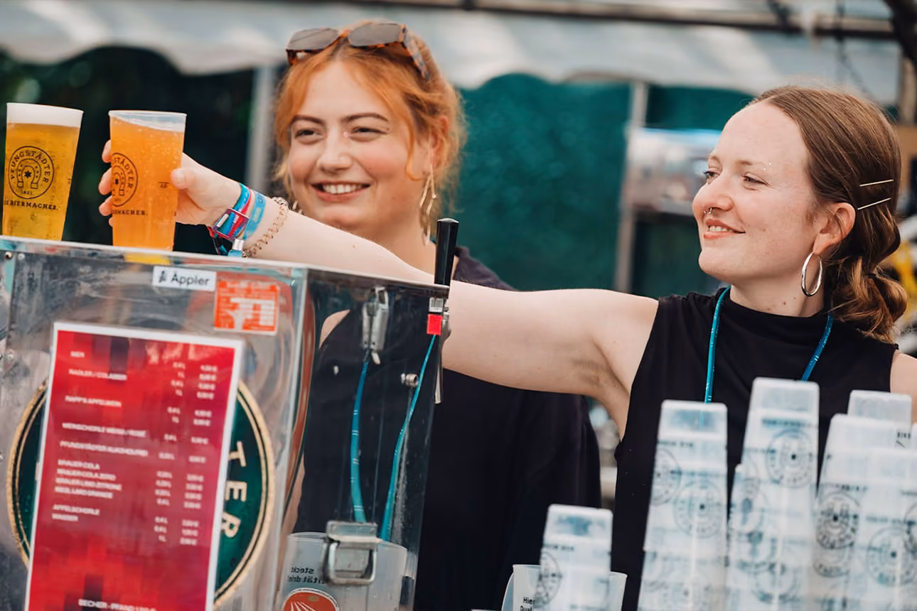 Zwei Frauen stehen hinter der Theke und geben Bier aus